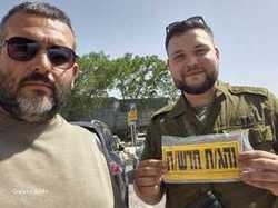 תלמיד מציג שלט נהג חדש יחד עם אבי המורה