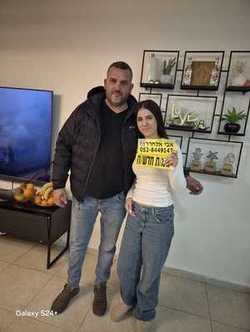 תלמידה מציגה לוחית נהג חדש לצד אבי